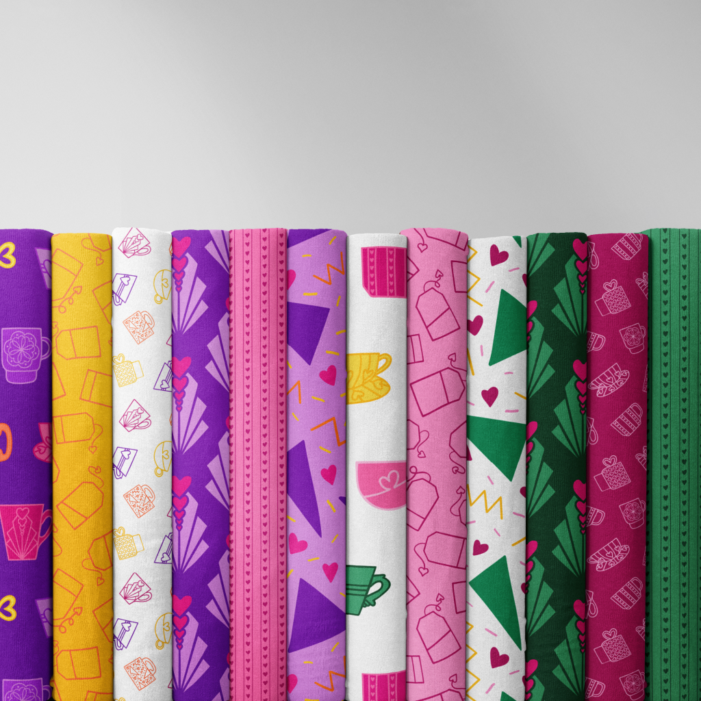 A row of fabric bolts in Fancy a Cuppa tea, cup and mug patterns in purple, pink, orange, yellow and green