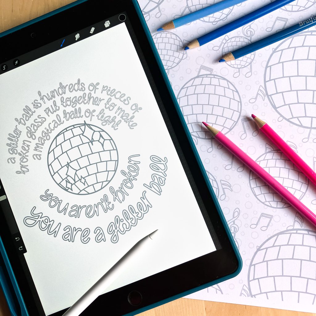 A photo of an ipad and a printed colouring sheet on a table. On the righ the ipad shows a colouring page featuring a glitterball and a quote, with an apple pencil resting on tip. On the right is a printed glitterball pattern colouring page with blue and pink colouring pencils lying on top.