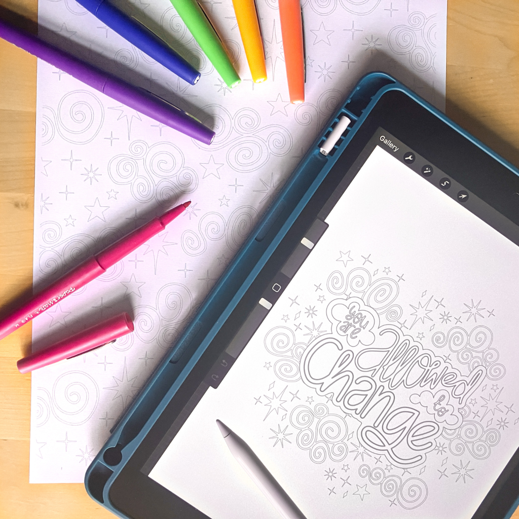 A photo of an ipad and a printed colouring sheet on a table. On the right the ipad shows a colouring page featuring a clouds, stars and a quote, with an apple pencil resting on tip. On the left is a printed cloud and star pattern colouring page with felt tip pens in rainbow colours lying on top.
