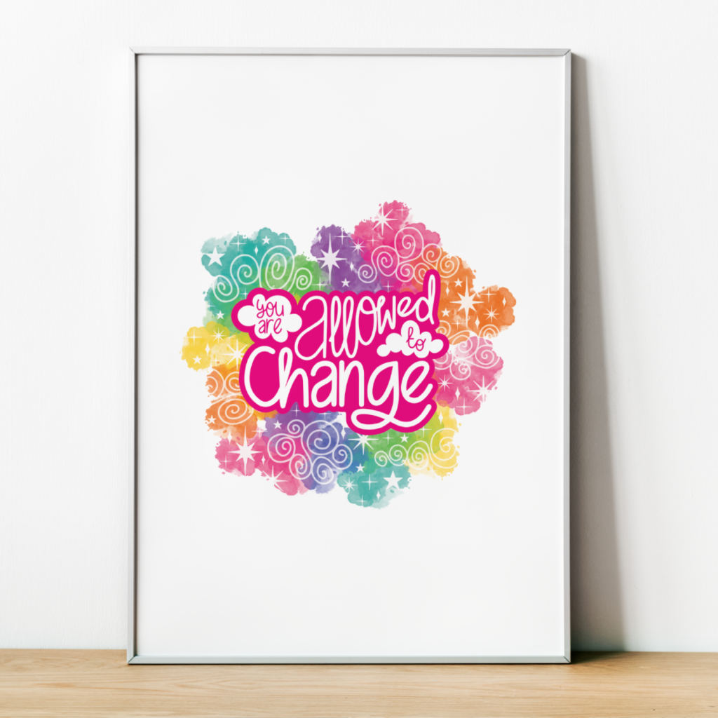 Mock up of an art print in a thin white frame leaning against a white wall. The art print has an illustrated quote "You are allowed to change" surrounded by rainbow clouds and white stars on a plain white background.